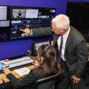 A professor directs a student in digital media.